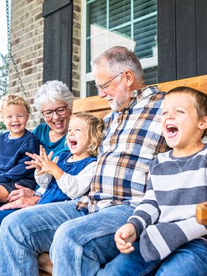 grandparents laughing with their grandkids