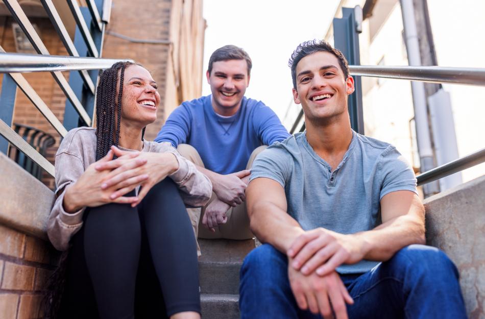 three young people sitting on steps