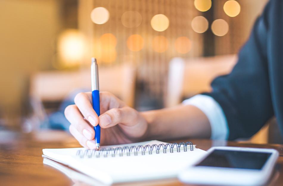 picture of someone writing in a notebook