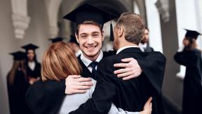 son hugging parents at graduation