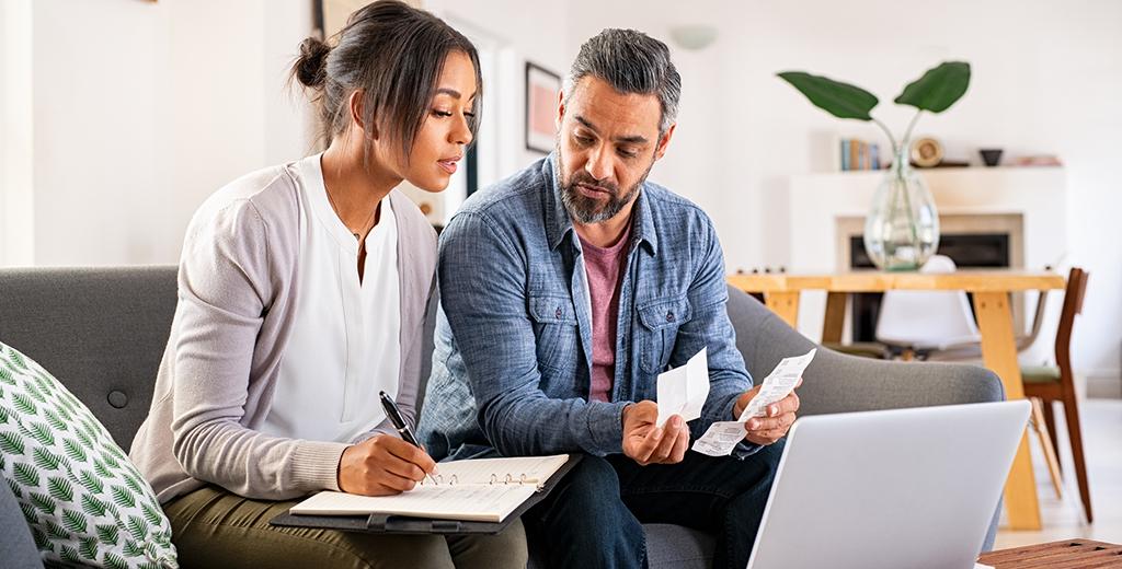 Two people sitting and creating a budget together. 