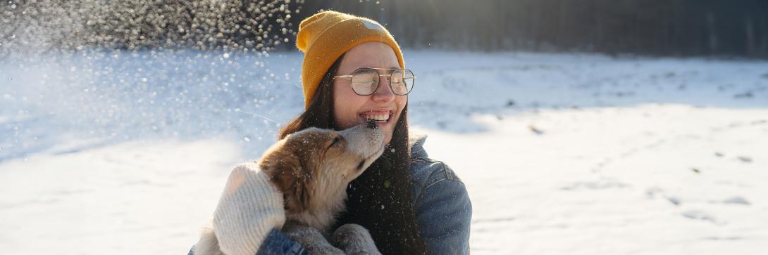 woman holding a dog in the snow